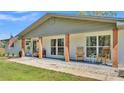 Close-up of a charming front porch with wood pillars and seating for relaxing and enjoying the view at 1535 Walker Rd, Lakeland, FL 33810