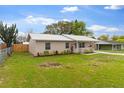 Side view of a cozy home featuring a metal roof and well-manicured lawn at 227 Dorothy St, Auburndale, FL 33823