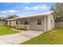 Image of the side of a one-story house with a metal roof, a well-maintained lawn, and an entry door at 227 Dorothy St, Auburndale, FL 33823