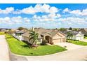 A manicured lawn and mature palms surround this attractive house with a three-car garage and stone facade at 2814 Sheldon St, Lakeland, FL 33813