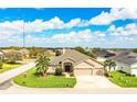 Charming home featuring a stone accent facade, a three-car garage, lush lawn, and mature palm trees at 2814 Sheldon St, Lakeland, FL 33813