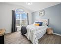 Bright main bedroom with a large window, wood-look floors, and stylish decor at 300 Keswick Ave, Davenport, FL 33897