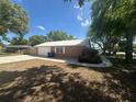 Side view shows the detached garage, manicured lawn, and convenient sidewalk around this home at 330 W Wellington Dr, Lakeland, FL 33813