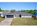 Charming single-story home with a gray exterior, updated roof, and an attached two-car garage at 4228 Sunny Land Dr, Lakeland, FL 33813