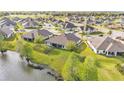 An elevated view showcases the home's backyard with lake frontage, complemented by mature trees at 5883 Great Salt Ct, Lakeland, FL 33805