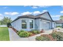 Home with a two-car garage, bay window, manicured shrubs, and a well-maintained lawn at 5883 Great Salt Ct, Lakeland, FL 33805