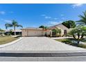 Stunning home showcasing a patterned brick driveway and lush landscaping under a clear blue sky at 6059 Condor Dr, Lakeland, FL 33809