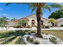 Attractive home displaying lush landscaping with vibrant plants and a stately palm tree in the front yard at 6059 Condor Dr, Lakeland, FL 33809