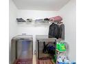 Laundry room with modern washer and dryer, wire shelving, and tiled floor at 661 Black Eagle Dr, Groveland, FL 34736
