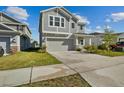 Charming two-story home featuring neutral gray siding, manicured lawn and an attached two-car garage at 728 Trotters Dr, Eagle Lake, FL 33839