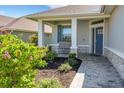 Inviting front porch with beautiful landscaping, stone accents, and a cozy seating area at 7947 Lake James Blvd, Lakeland, FL 33810