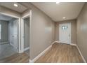 Inviting entryway featuring wood-look flooring, neutral walls, and a bright white front door with decorative glass at 1013 Rhodes S Rd, Haines City, FL 33844