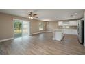 Open living space with wood-look floors, abundant natural light, and an island kitchen at 1013 Rhodes S Rd, Haines City, FL 33844