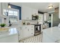 Bright kitchen features white cabinets, marble countertops and stainless steel appliances at 1028 W Marjorie St, Lakeland, FL 33815