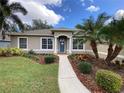 Attractive single-Gathering home with a beautifully landscaped front yard and a welcoming blue front door at 10812 Versailles Blvd. Blvd, Clermont, FL 34711