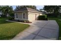 Detached two-car garage with a wide driveway and well-maintained landscaping at 10812 Versailles Blvd. Blvd, Clermont, FL 34711