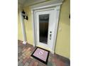 A welcoming front door with decorative trim, stylish doormat, and colorful brick walkway creates curb appeal at 11953 Delfina Ln, Orlando, FL 32827