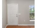 A simple entryway featuring a white six-panel door and a window providing natural light at 120 Flatfish Ct, Kissimmee, FL 34759