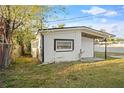 Rear view of the home, showcasing its simple architectural design and side yard at 126 Mason St, Auburndale, FL 33823
