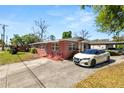 View of a single story brick home featuring a convenient driveway and carport at 1306 N Webster Ave, Lakeland, FL 33805