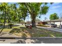 Exterior shot of a well-shaded home with mature tree and a convenient carport at 1306 N Webster Ave, Lakeland, FL 33805