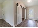 View of the foyer features a modern barn door and stylish wood-look floors at 13650 Sw 43Rd Cir, Ocala, FL 34473
