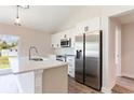Bright open kitchen features white cabinets and a stainless steel refrigerator at 13650 Sw 43Rd Cir, Ocala, FL 34473