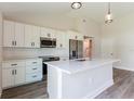 Bright kitchen features white cabinets, stainless steel appliances, and a center island at 13650 Sw 43Rd Cir, Ocala, FL 34473