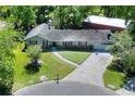 An aerial view of a single story home, showcasing the landscaped yard and surrounding neighborhood at 1655 John Arthur Way, Lakeland, FL 33803