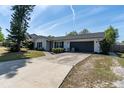 Front exterior featuring a two-car garage, well-manicured lawn, and charming curb appeal at 221 Stevenson Rd, Winter Haven, FL 33884