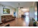 Spacious living room featuring hardwood floors, a ceiling fan, and comfortable leather sofas at 2329 Duff Rd, Lakeland, FL 33810