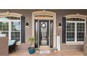 Inviting entryway featuring a decorative glass front door, sconces, and potted plants at 2569 Colonel Ford Dr, Lakeland, FL 33813