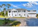 Elegant two-story white home with spacious front yard and large driveway leading to attached garage at 2653 State Road 557, Lake Alfred, FL 33850