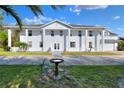 Stately two-story home with white siding, columns, and a manicured front lawn on a sunny day at 2653 State Road 557, Lake Alfred, FL 33850