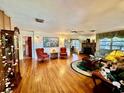 Spacious living room featuring hardwood floors, a stone fireplace, and ample natural light at 302 Luna Rd, Auburndale, FL 33823