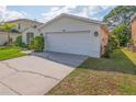 Exterior view of a white home featuring a two-car garage and well-maintained landscaping at 307 Balmoral Ct, Davenport, FL 33896