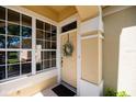 Close-up of front door with wreath, sidelight windows, and inviting entryway with colorful accents at 3071 Shoal Creek Village Dr, Lakeland, FL 33803