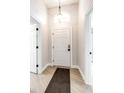 Bright entryway featuring light wood flooring, a white front door, and modern lighting fixtures at 3080 Westmoreland Dr, Lakeland, FL 33810