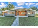 Charming single-story home featuring a modern exterior, natural wood accents, and well-manicured front yard at 3134 Hilltop S Ave, Lakeland, FL 33803