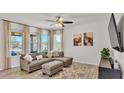 Cozy living room with large windows, neutral decor, and comfortable seating arrangement at 4232 Prima Lago Dr, Lakeland, FL 33810