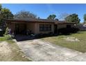 Single story brick home with a covered carport and a well-manicured lawn at 460 W Pierce St, Lake Alfred, FL 33850