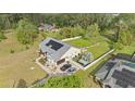 Aerial view of home with metal roof, a two car garage, and wooded backdrop at 6745 Old Melbourne Hwy, St Cloud, FL 34771
