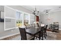 Elegant dining room featuring hardwood floors, a decorative chandelier, and large, bright windows at 6745 Old Melbourne Hwy, St Cloud, FL 34771
