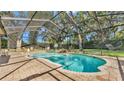 Screened-in pool area featuring a free-form pool with rock waterfall feature and outdoor seating at 6774 Crescent Woods Cir, Lakeland, FL 33813