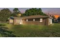 View of the rear of the home with an enclosed lanai, well-maintained lawn, and partial view of a fenced property at 6981 Snell Rd, Bartow, FL 33830