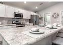 Bright kitchen featuring stainless steel appliances, white cabinets, and a spacious island with seating at 7576 Sw 108 Th St, Ocala, FL 34476