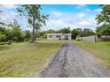 Long gravel driveway leading to a well-maintained home with mature trees at 900 Saddlewood Blvd, Lakeland, FL 33809