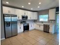 Modern kitchen featuring stainless steel appliances, sleek white cabinets, and tile flooring at 1018 Roberta Rd, Lake Wales, FL 33853