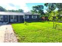 Well-manicured front yard with lush green grass and mature trees surrounding the property at 1024 31St Nw St, Winter Haven, FL 33881