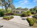 Beautiful white home with landscaped front yard, circular driveway, and healthy palm trees on a sunny day at 1390 S 1St Ave, Bartow, FL 33830